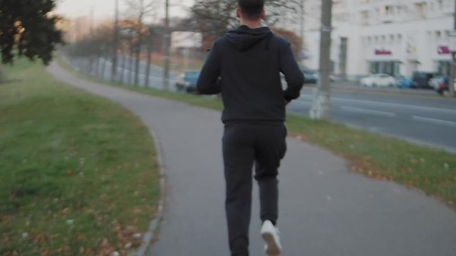 A man runs through the morning city.