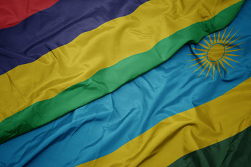 waving colorful flag of rwanda and national flag of mauritius.