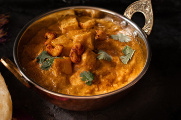 Indian cottage cheese with flat breads served in copper bowl