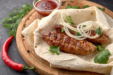 Lula kebab with pita bread on a wooden board