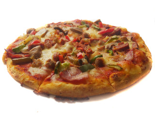 Pizza in round shape, topped with meat, ham, mushroom and veggies
