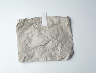 gray crumpled sheet of paper glued with white adhesive tape