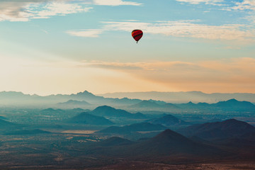 Hot Air Balloon floating over the Misty Mountains of the Arizona Desert near Phoenix