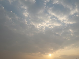 Naklejka na ściany i meble A view of sunrise with blue sky and puffy white clouds 