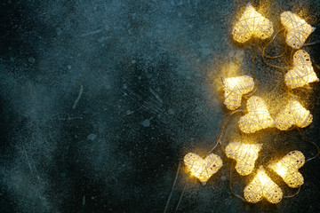 Beautiful heart-shaped fairy lights glowing on dark . St. Valentine's Day background