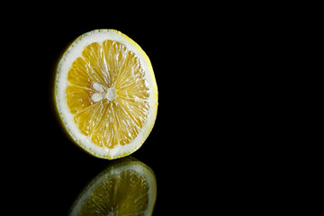 Close up view of lemon piece isolated on black.