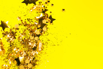 Golden sparkles on yellow background. Holiday concept.
