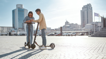 Best options for good choices. Friends going to use electric scooter in city. © Svitlana