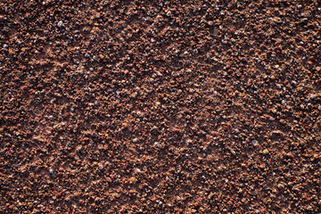 Fine red metal ore rich gravel and sand, flat surface in hard sunset light, resemblance to Mars surface.
