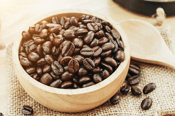 Coffee bean on wooden bowl with home made coffee background