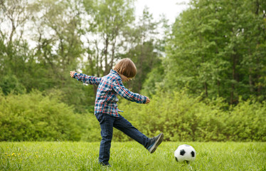 Sports Kid. Baby playing soccer ball in the park. Children play football. Family leisure.