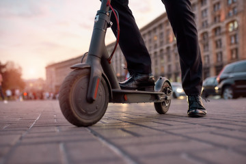 Ready to go. Businessman on daily commute riding scooter along the street © Svitlana
