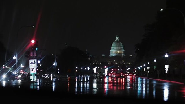 Rainy night driving in Washington D.C. Capital city. Stopped at stoplight, Capitol Building in the background.