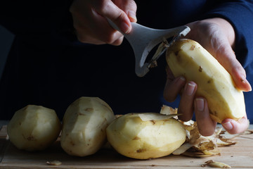 A women show how to peel a potato using kitchen tool