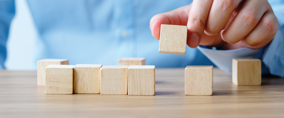 Hand holding blank wooden block cubes on table background, business concept background, mock up, template, banner