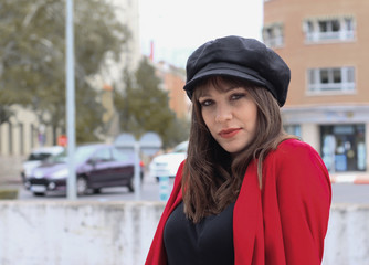 Beautiful young woman with red jacket and leather cap