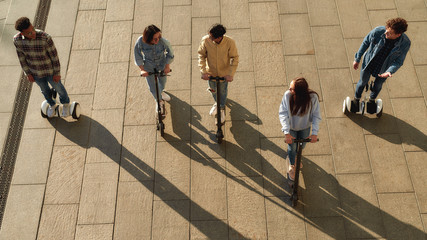 Create memories. Joyful friends riding kick scooters and segways