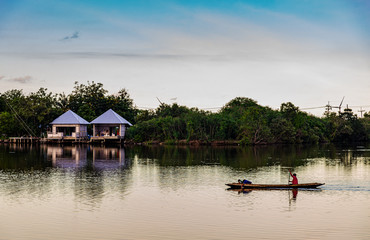 Fisherman with boat in river and sunset countryside
