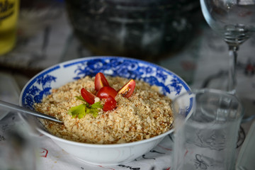 Traditional brazilian farofa cassava flour mixture with tomatoes on top