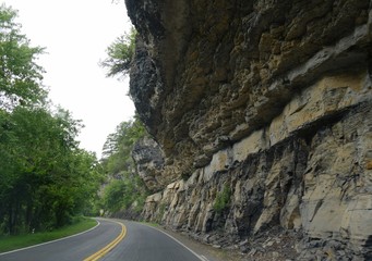 Scenic drive on a winding road with rock walls jutting out over the road