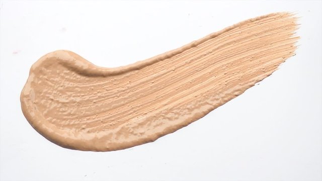 Foundation face make-up smudge, smear. Cosmetic liquid foundation or bb cream beige color smudge, smear, stroke. Make up smears isolated on a white background. Brush. Texture. 4K UHD video