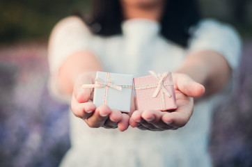 The girl handed the gift box with a beautiful smile and a happy holiday.