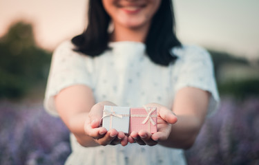 The girl handed the gift box with a beautiful smile and a happy holiday.