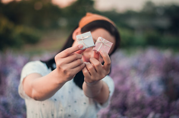 The girl handed the gift box with a beautiful smile and a happy holiday.