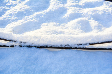 Fragment of a forged fence covered with snow