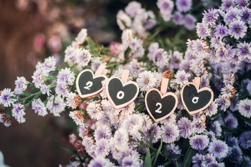 Happy New Year festival background with gold numbers 2020 along the purple flower fields And according to the holiday season to welcome this new year