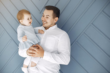 Fototapeta premium Handsome dad with child. Man in a white t-shirt. Little girl at home