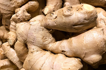 Dry golden ginger roots close-up on a counter in a greengrocery. Texture view