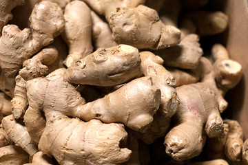A box with a bunch of dry brown ginger roots on a counter in a greengrocer