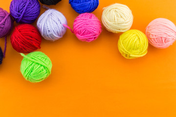 yarn many color top view on orange background.