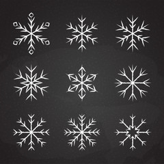 Set of icy snowflakes symbol vector illustration. White chalk sketch frozen snowflake isolated on blackboard for new year celebration snow decoration ornament or christmas festive frost flakes design