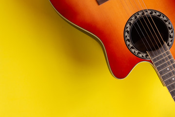 Top view electro acoustic guitar over yellow background. Musician and guitarist player concept.