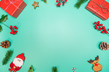 Christmas background concept. Top view of Christmas decoration, Santa Claus and reindeer with red gift box on green background