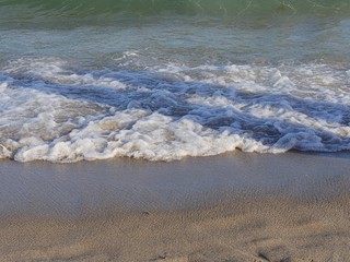 Waves breaking and creating a flowing patterns on the beach