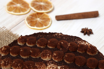 DeliciousTiramisu cake close-up on a white wooden background.