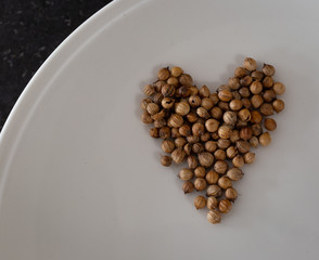 Coriander Seeds Formed into a Heart on a White Plate