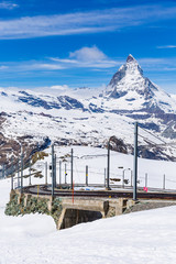 Scenic view on snowy Matterhorn peak in sunny day with some clouds, Switzerland.