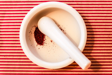 Stockholm, Sweden A mortar and pestle used to grind saffran in hot water surrounded by walnuts, cinnamon sticks and mandarins.