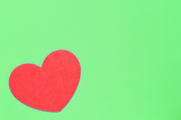 Red heart on a light green background closeup. Greeting card with copy space. Valentine's Day concept