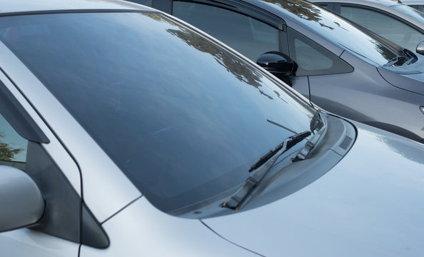 Close-up  front glass, window of the car and the side left mirror  on the street