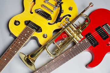 Obraz premium Two electric guitar and trumpet on a light background.