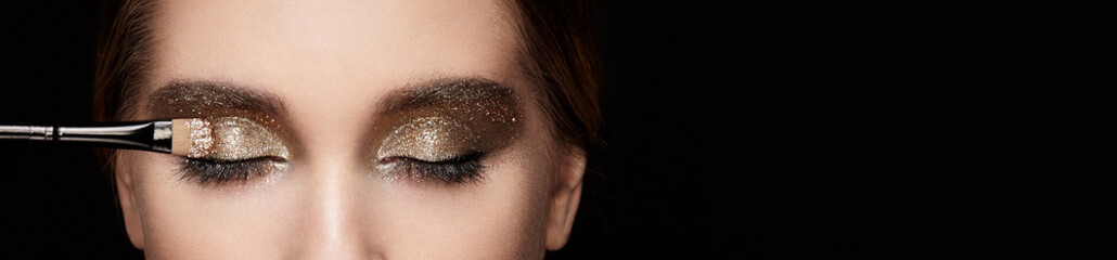 Makeup artist applies eye shadow. Beautiful woman face. Perfect makeup. Lips. Cosmetic Eyeshadow....