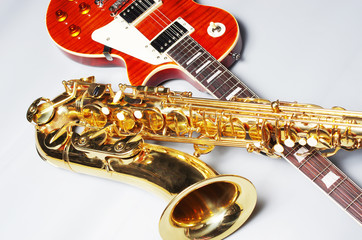 Electric guitar and saxophone on a light background.