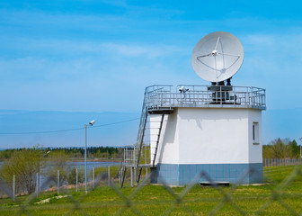 Satellite dish directed to the sky. Building with a satellite dish attached to it.