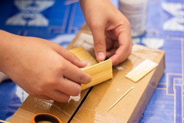  Craft work using small pieces of wood to make a model house.