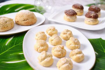 choux cream or cream puff or French profiteroles with fresh cream set on cafe table.